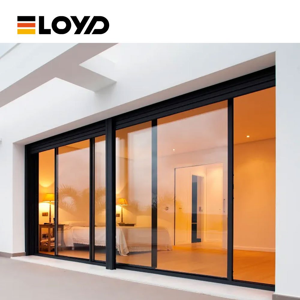 LOYD black minimalist sliding door installed in a bedroom, revealing a cozy interior with a bed, nightstand, and warm lamp light.