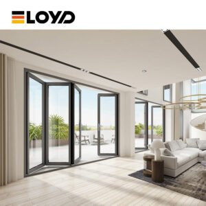 Interior view of a modern living room with ELOYD black folding glass doors open to a balcony with plants and furniture.