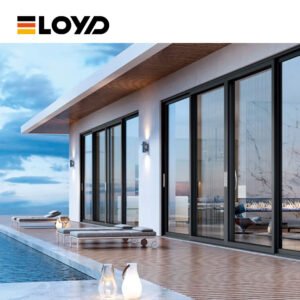 A black ELOYD sliding door installed in a white wall, with a wall-mounted lamp, opening to a wooden deck with lounge chairs and a swimming pool overlooking a sea view.